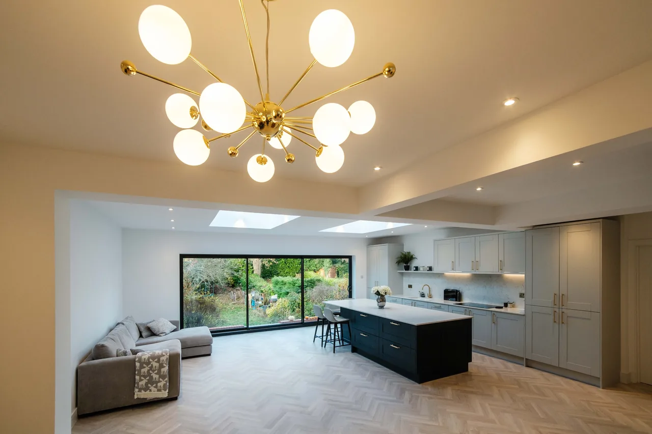 A kitchen island lit by linear pendant lighting