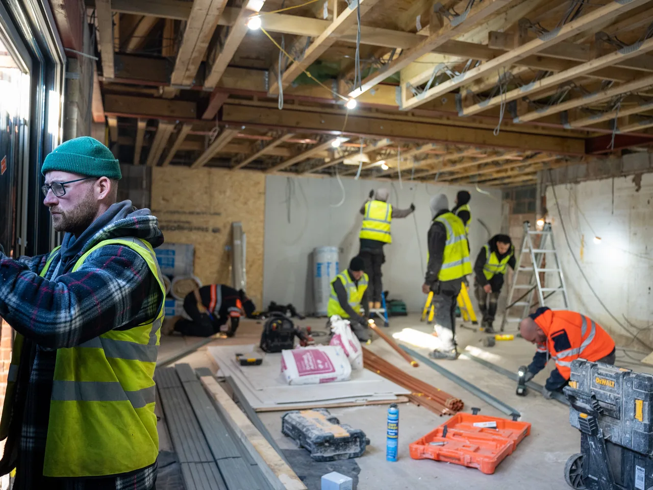 A site supervisor briefing an installation team amid exposed ceiling services